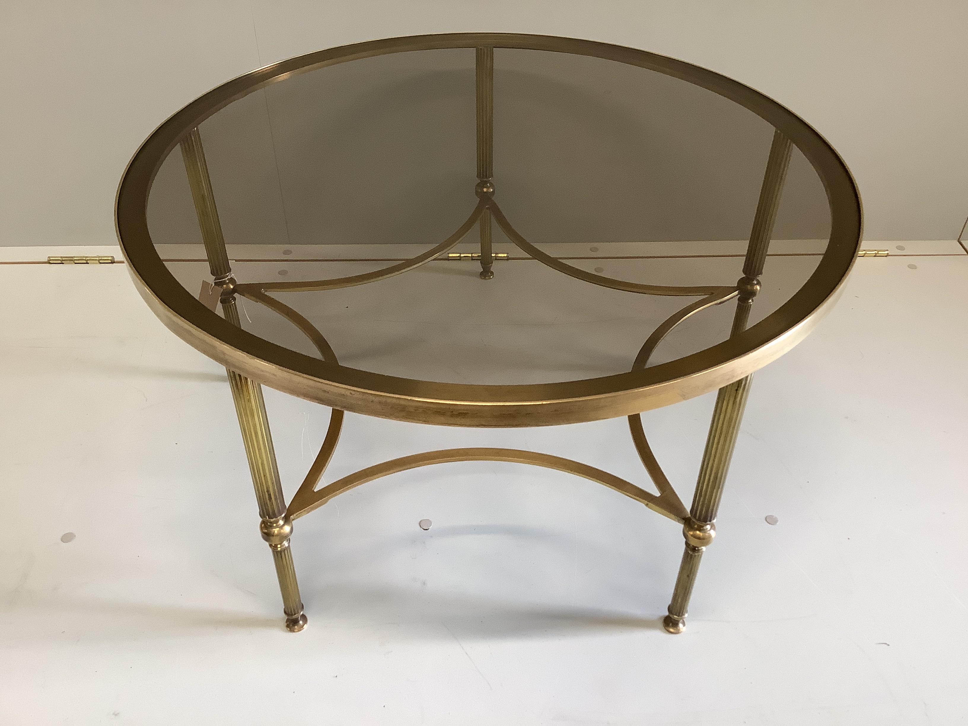 A Maison Jansen style circular brass, glass top coffee table, 76cm diameter, height 42cm